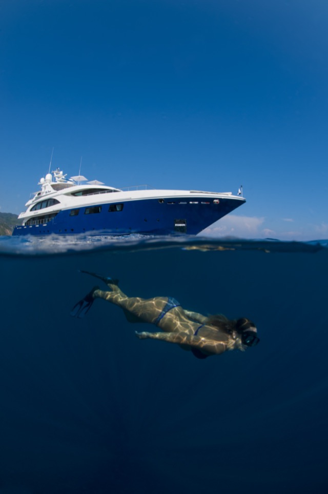Swimmer underwater beneath M/Y My Dream, half-water view