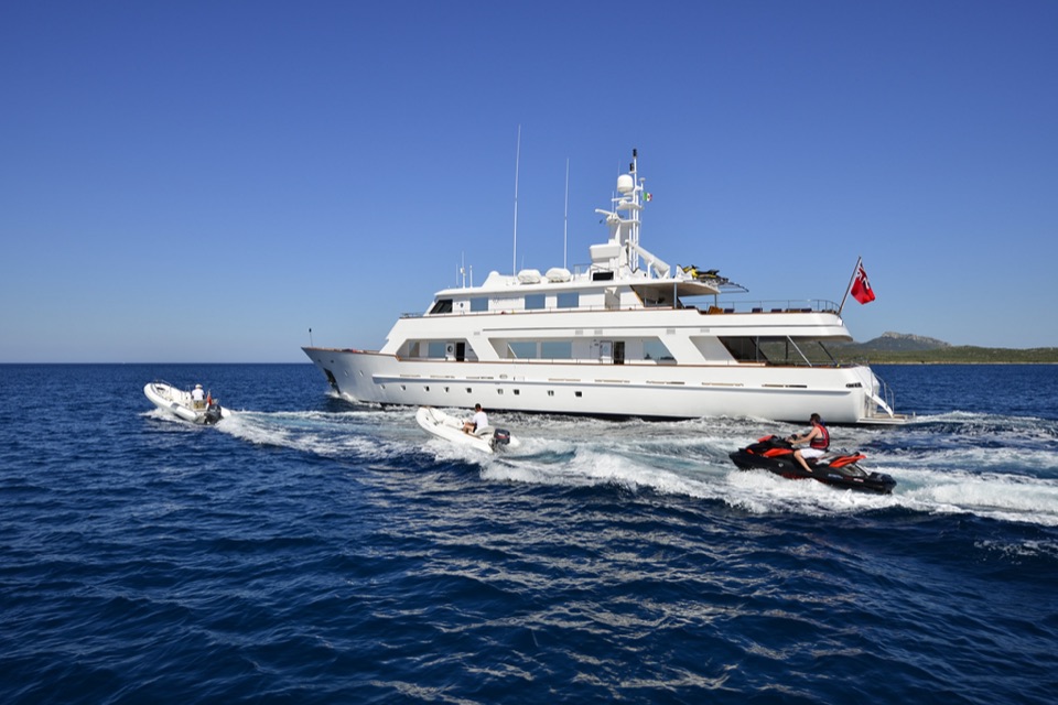 M/Y Commitment underway escorted by her tender and a jet ski